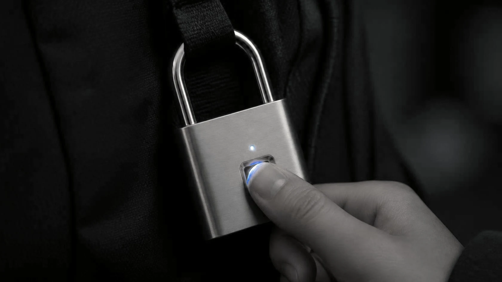 Un dedo toca el sensor del candado y la luz azul se enciende